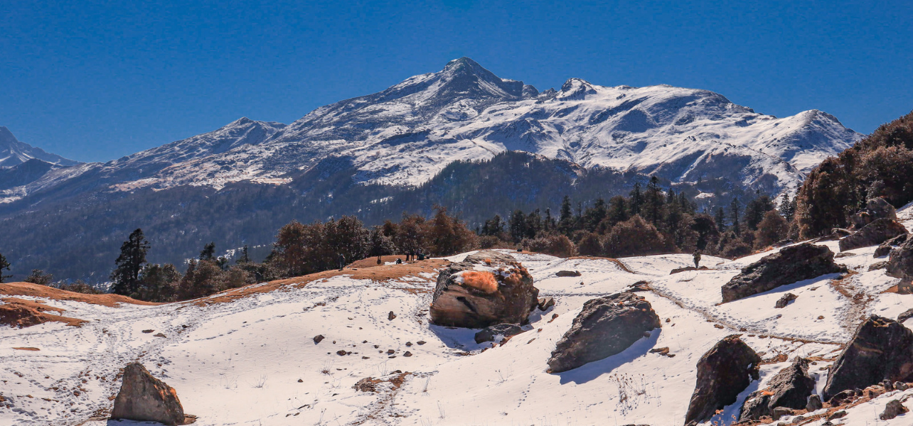 Snow-covered Himalayan mountain peaks and snow path on the Kuari Pass Trek near Joshimath Uttarakhand.