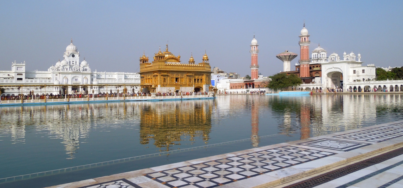 Wide angle view of Golden Temple Amritsar tour Package complex with sarovar and surrounding buildings
