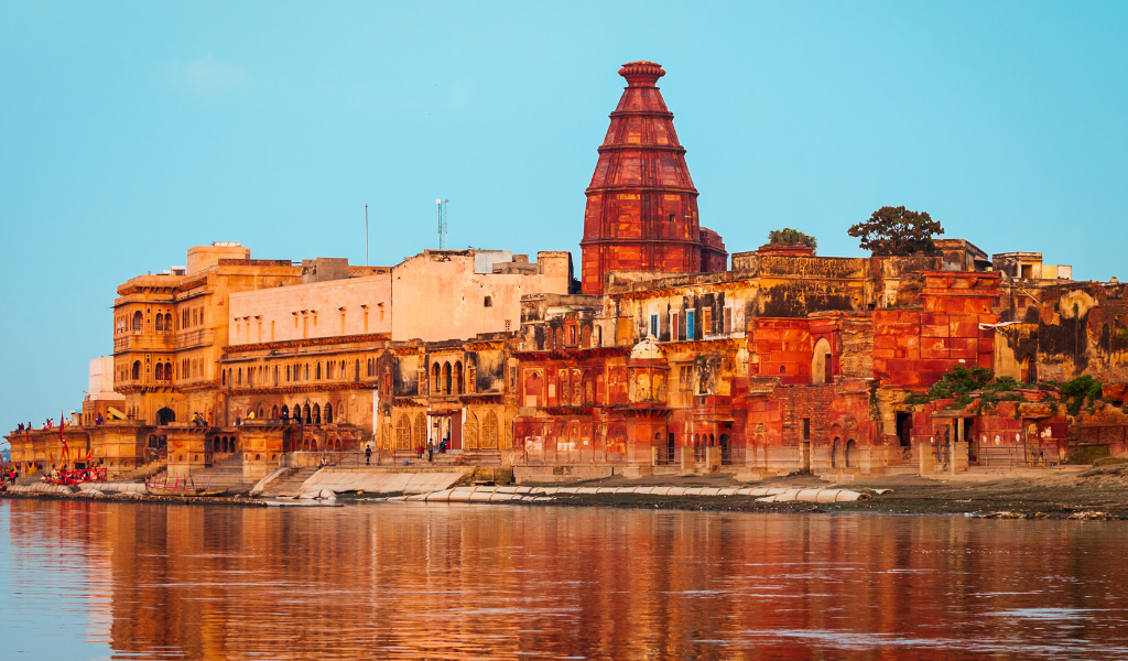 Historic red stone temples along the riverbanks, showcasing the 5,000-year-old heritage found during a Mathura sightseeing Tour
