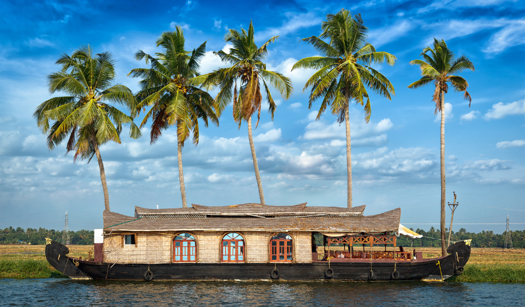 Traditional houseboat sailing in Kerala Tour Package backwaters surrounded by palm trees and scenic nature