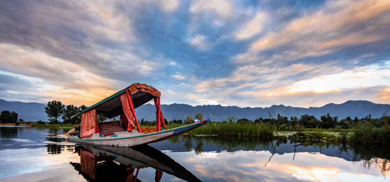 Shikara ride on Dal Lake in Srinagar Kashmir with beautiful mountains and sunset view
