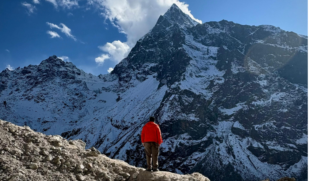 Trekker gazing at snow-capped Himalayan mountain peaks booked through binsar tour itinerary.