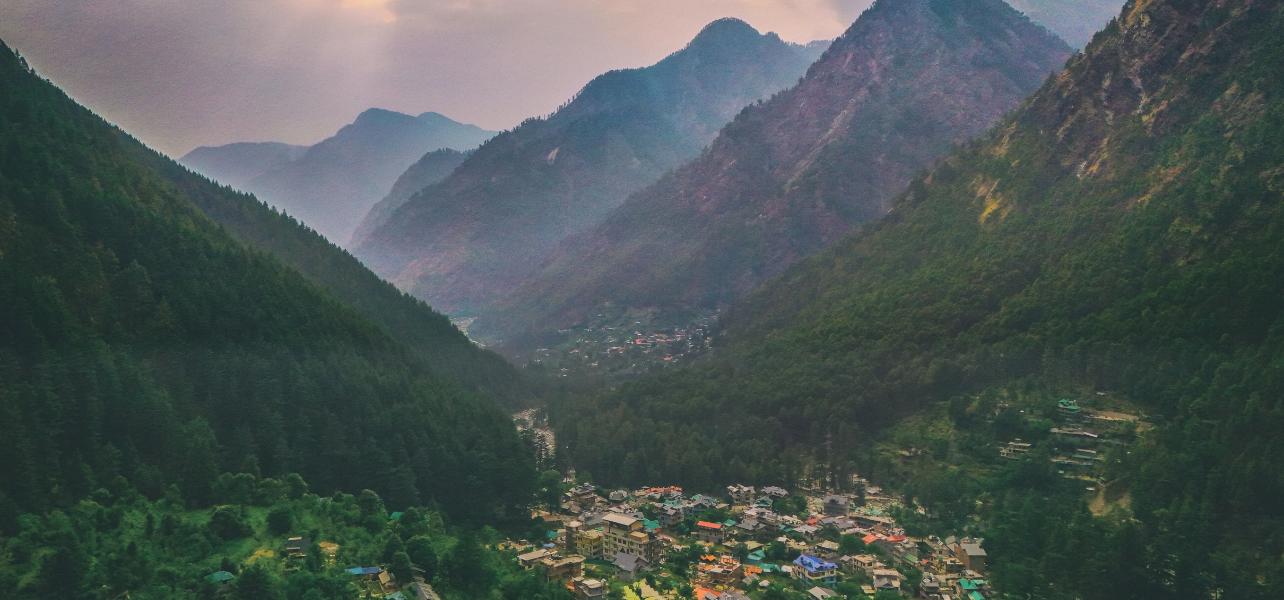 Kasol Tour Package panoramic mountain valley surrounded by dense pine forests