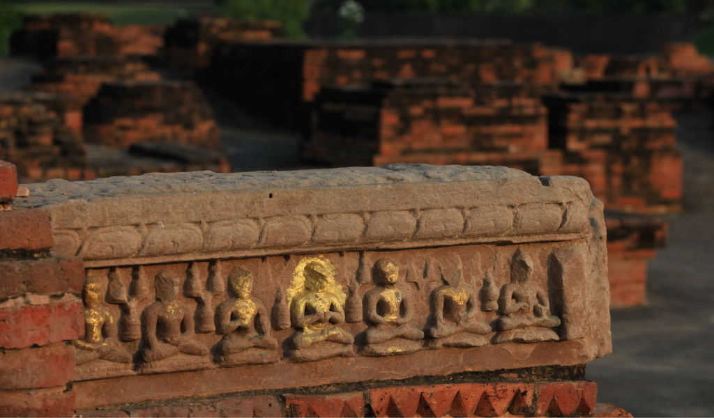 Detailed ancient stone carvings of Buddha figures found at the historic site during a guided Sarnath tour package