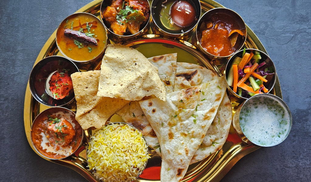 Art and culture of India food heritage displaying an authentic Indian thali with curries, naan, rice, and desserts.