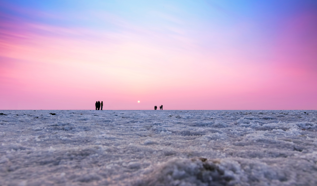 Beautiful sunset view of the white salt desert with tourists – a key highlight of our Rann of Kutch festival packages by India Easy Trip.