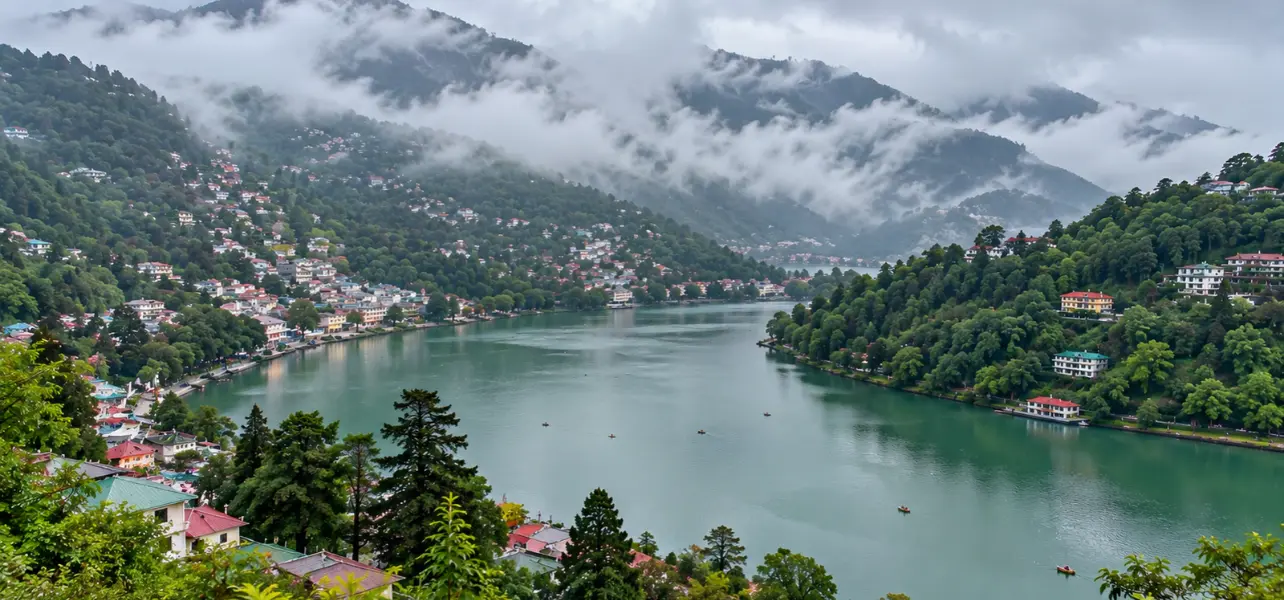 Nainital Tour Package from Haridwar featuring a scenic view of Naini Lake surrounded by lush green hills and misty mountains.
