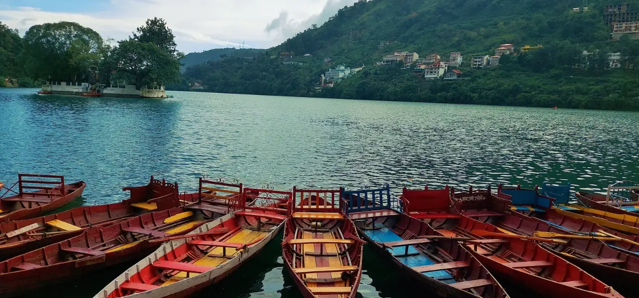 Nainital Lakes Tour Package with traditional wooden boats on the scenic lake surrounded by green hills in Nainital, Uttarakhand