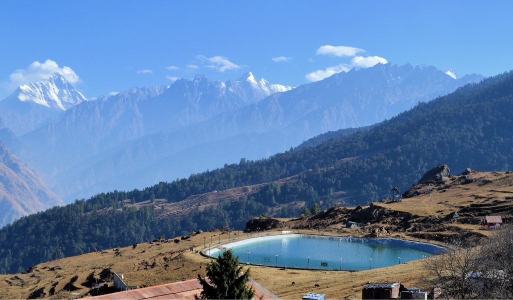 Auli package highlighting the pristine artificial lake surrounded by pine slopes and snow-capped Himalayan peaks.