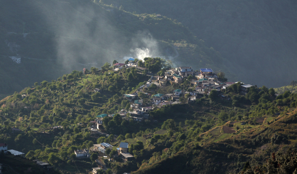 Scenic view of green hills and houses for your Mussoorie tour package