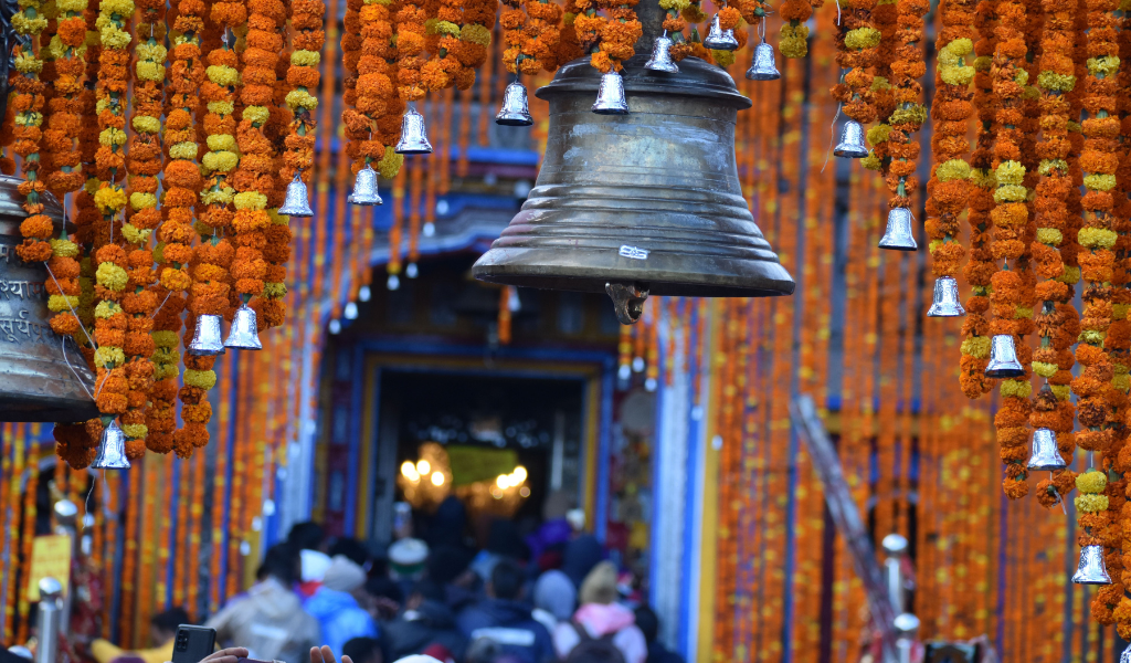 Traditional brass bells and marigold garland decorations at a Char Dham temple entrance during Char Dham Yatra from Chennai.