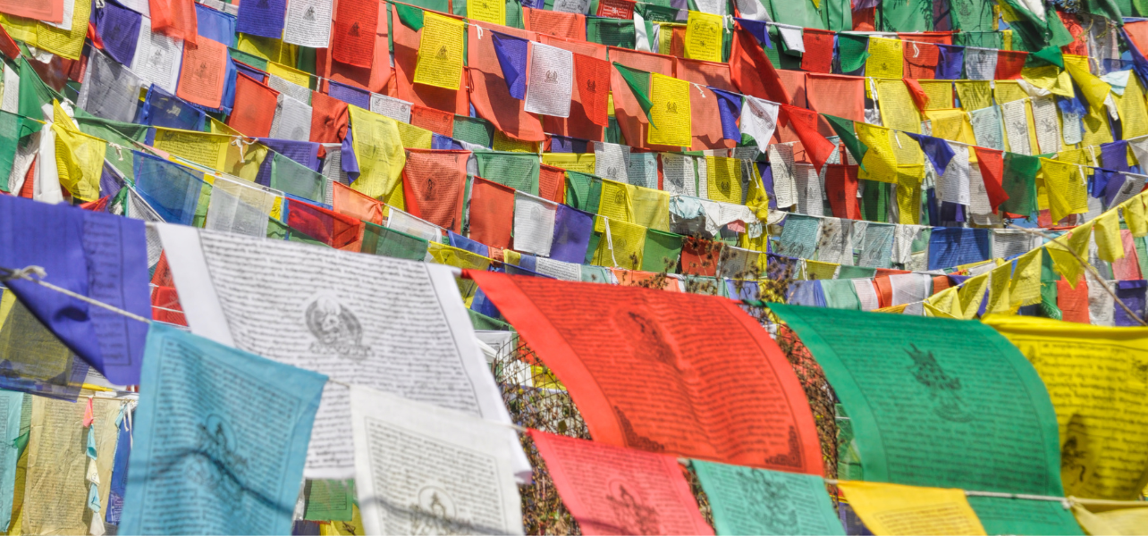 Amritsar Dalhousie Dharamshala Tour Package featuring colorful Tibetan prayer flags in the mountains