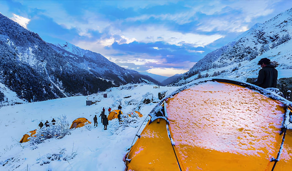 Yellow camping tents pitched on a snow-covered mountain campsite during the Har Ki Dun trek in winter.