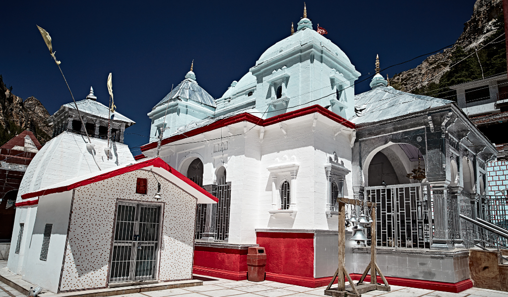 Side view of the white Gangotri Temple with flags, visited during the 4 Dham Yatra from Delhi.