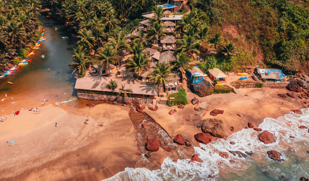 Aerial view of vibrant beach shacks and cozy huts on the Goa coastline, a highlight of our Goa Tour Package From Delhi tailored for romantic goa for couples.