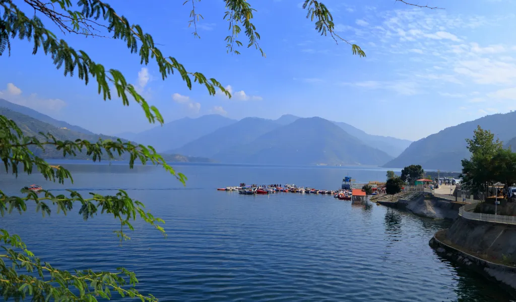 Tehri Lake scenic view with blue water and surrounding Himalayan hills during Kanatal sightseeing in Uttarakhand