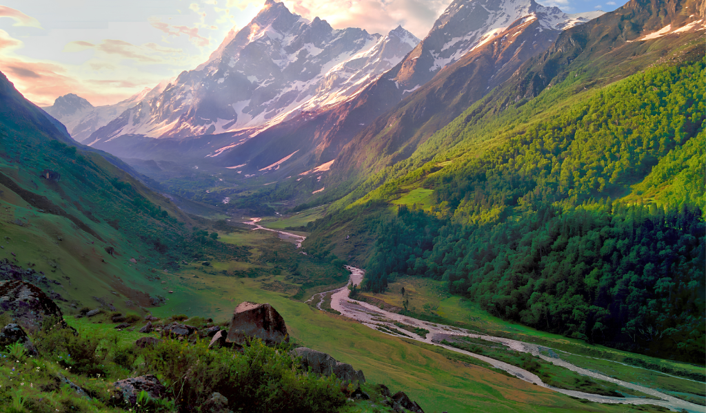 Panoramic view of the green Har Ki Dun valley trek with winding river  under a warm sunset sky near Swargarohini peak.
