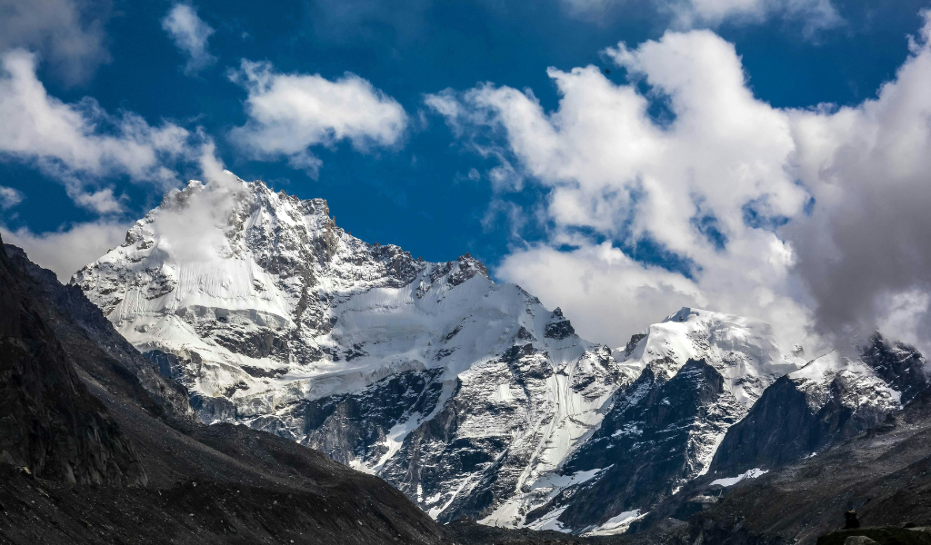 Beautiful snow capped Himalayan mountain peaks under blue sky featured in Shimla tourist package sightseeing.