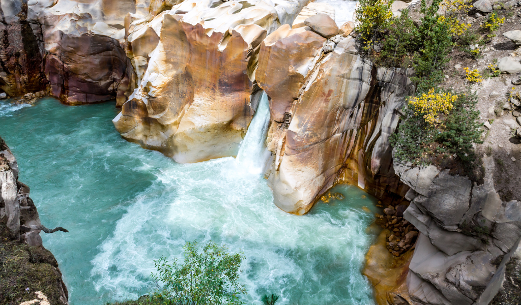 River flowing through rocky gorge near Gangotri on a chardham yatra package from Chandigarh.